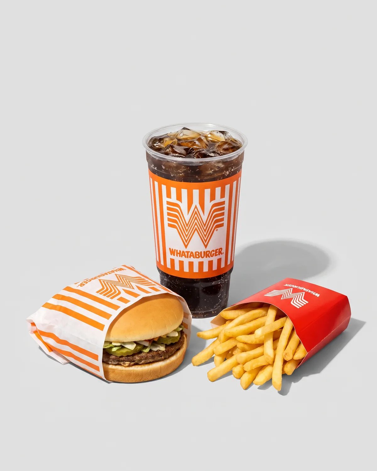 A Whataburger, fries and a drink in the orange-striped wrapper and cup