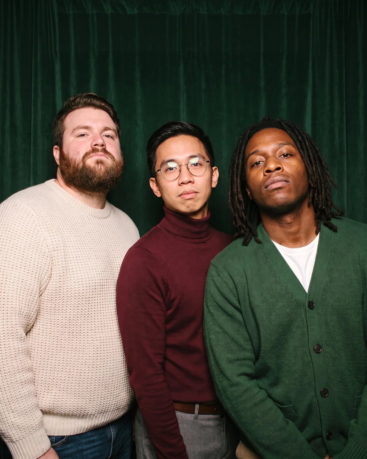 Three friends striking a serious pose at a holiday party