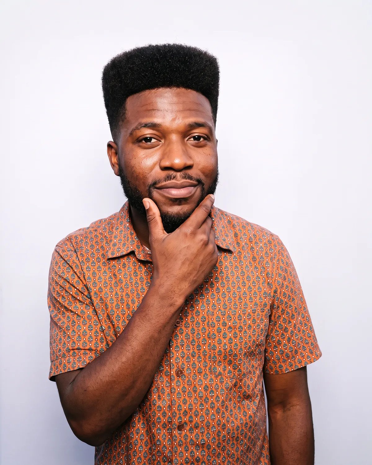 Guest at a brand launch party in a patterned shirt, rubbing his chin as he thinks of an idea