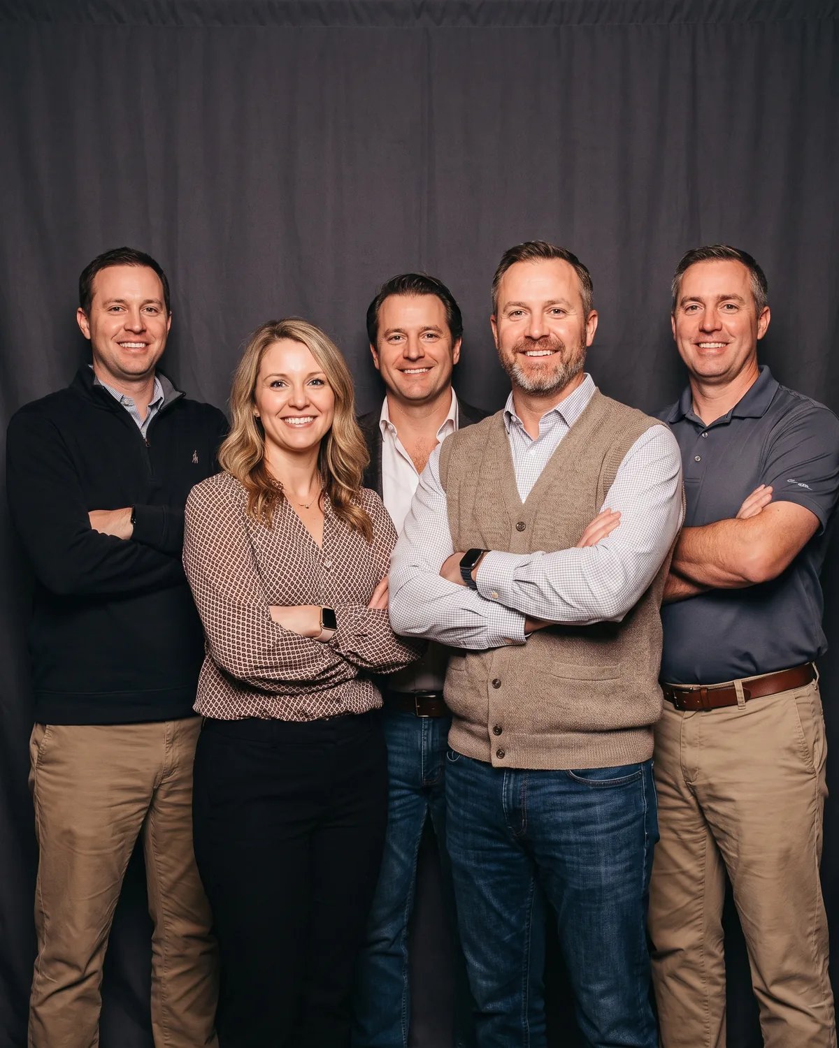 Five coworkers at a sales kickoff with their arms crossed like a team photo