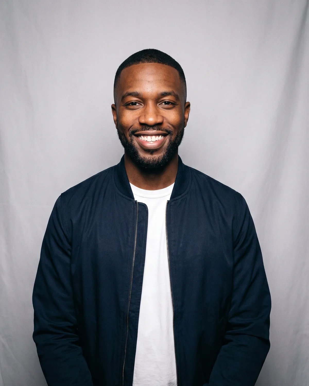 Guest at a company holiday party in a navy bomber jacket, photographed by the booth