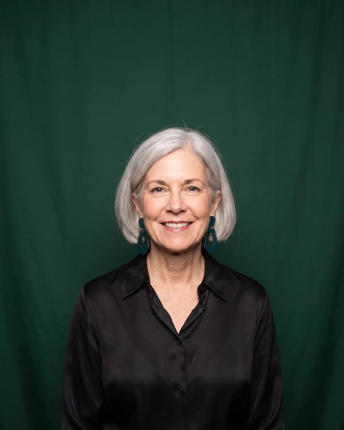 Guest at an art gala with a silver bob, in a black silk blouse