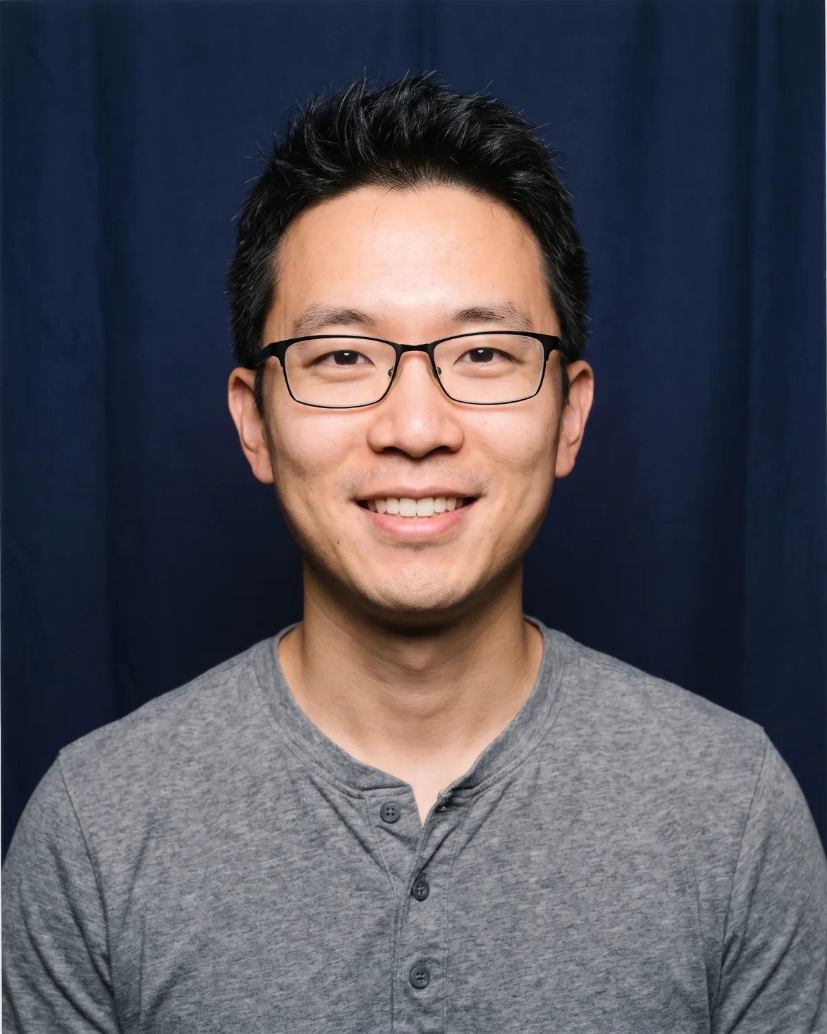 Attendee at a tech conference in glasses and a gray henley