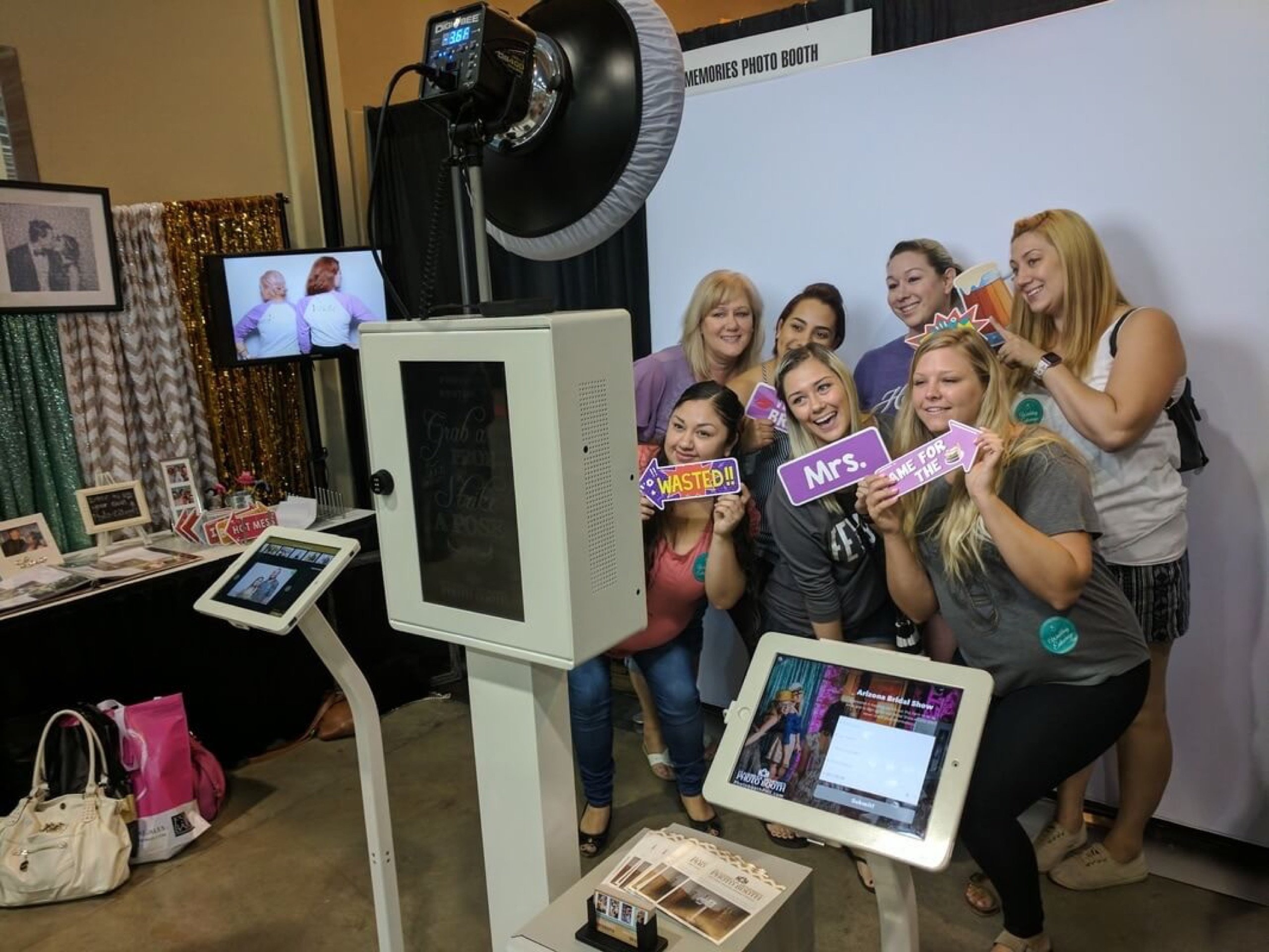 Brides-to-be holding 'Mrs.' props at the Flashbulb Memories booth during the Arizona Bridal Show at the Phoenix Convention Center, June 11, 2017