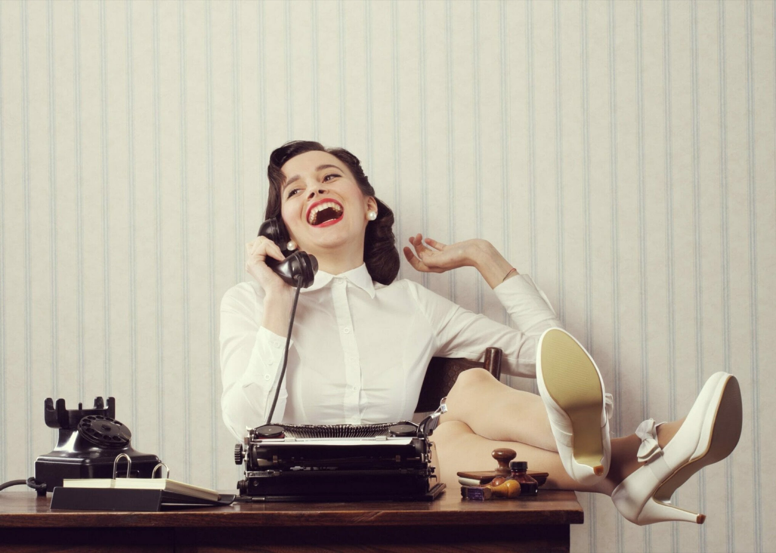 Guest laughing into a vintage telephone handset while leaving an audio guest book message