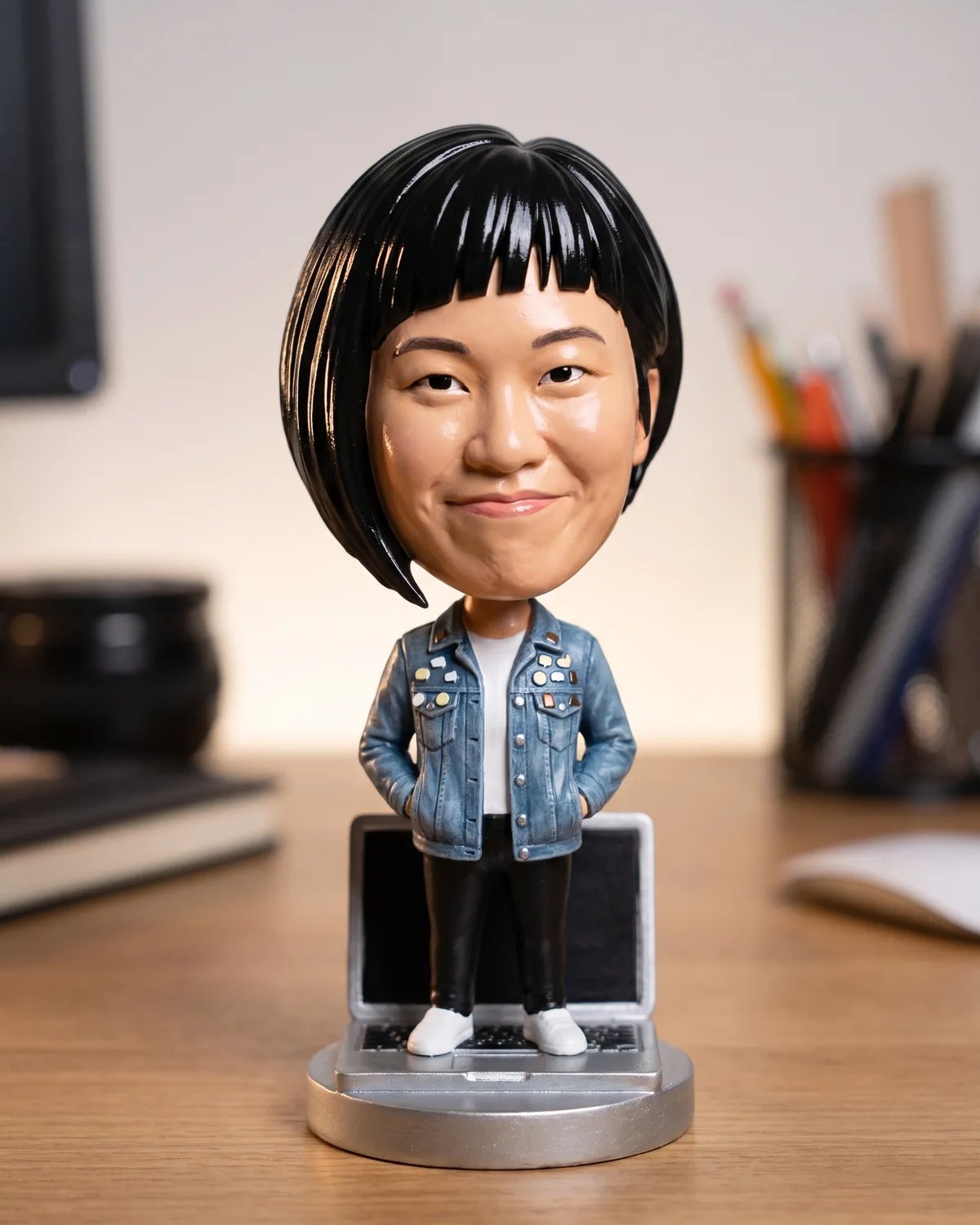 The guest as a bobblehead on a laptop-shaped base on a desk