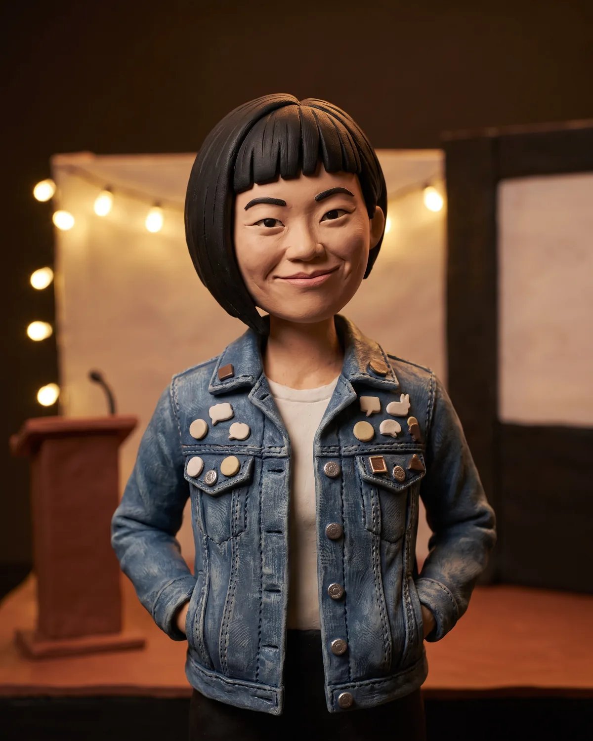 The guest as a stop-motion clay figure on a miniature conference stage