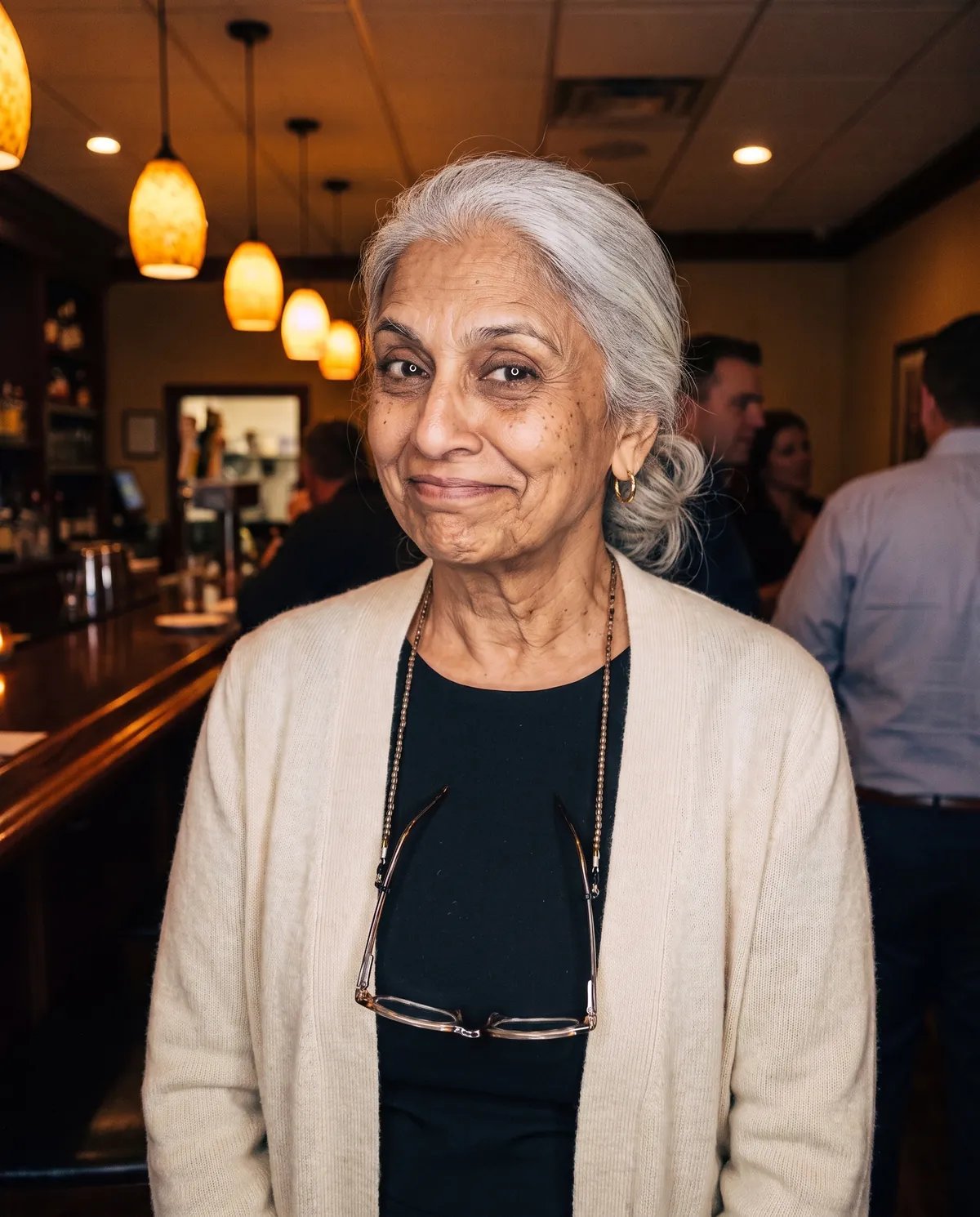 The same guest at 80 in the same spot, silver hair and the same wry half smile