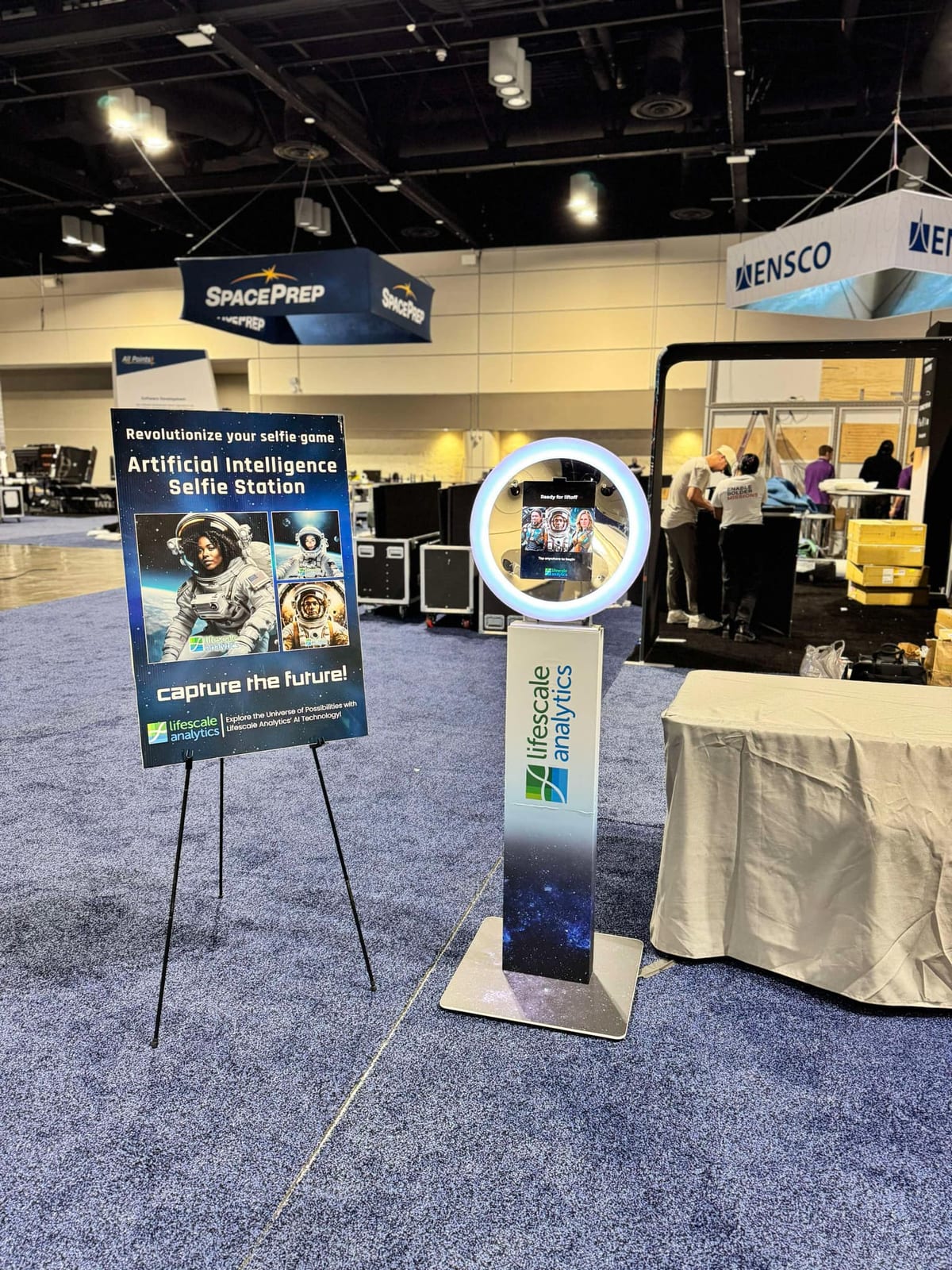 Lifescale Analytics AI selfie station with a space-themed wrap and matching easel sign at a trade show