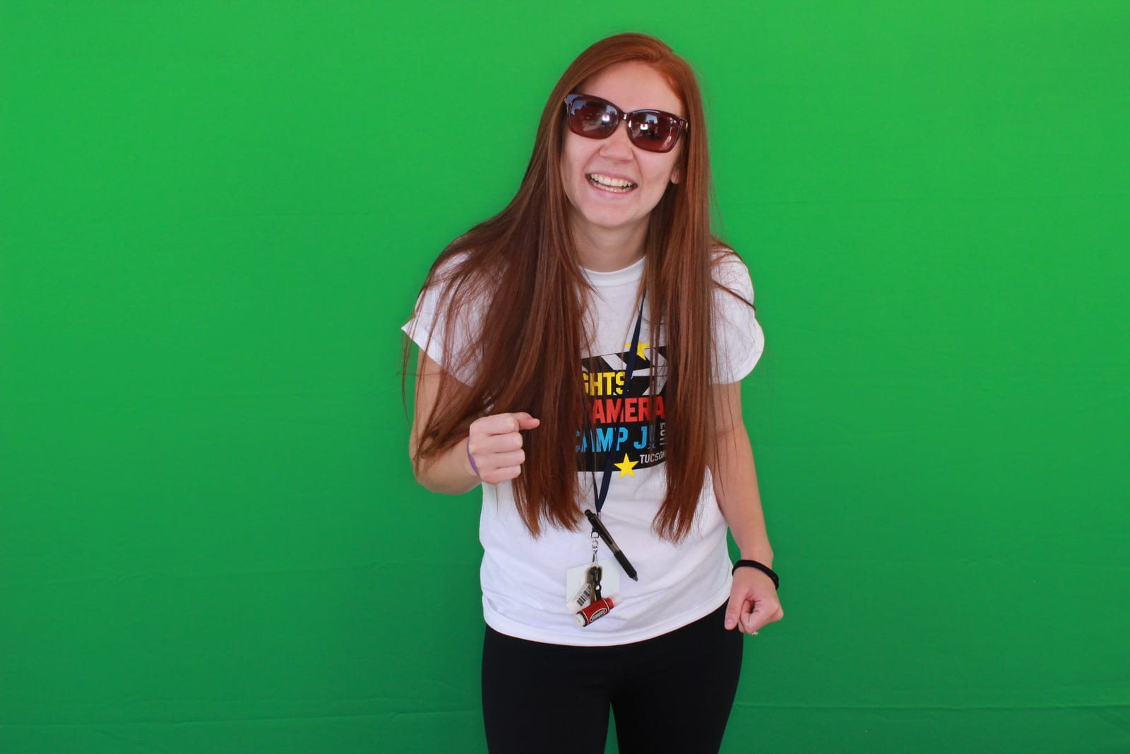 A guest standing in front of a green screen photo booth backdrop before the background is replaced
