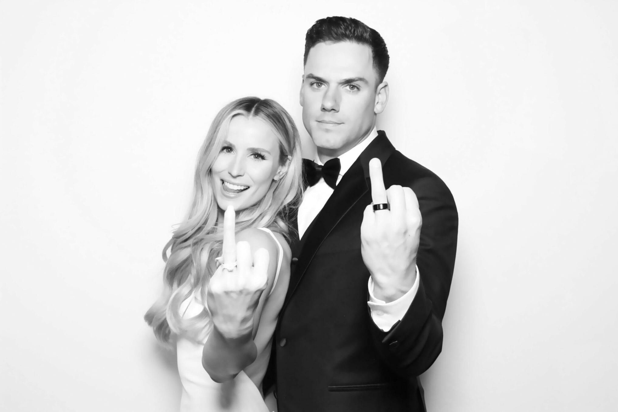 Newlyweds showing off their wedding rings in a black and white glam portrait