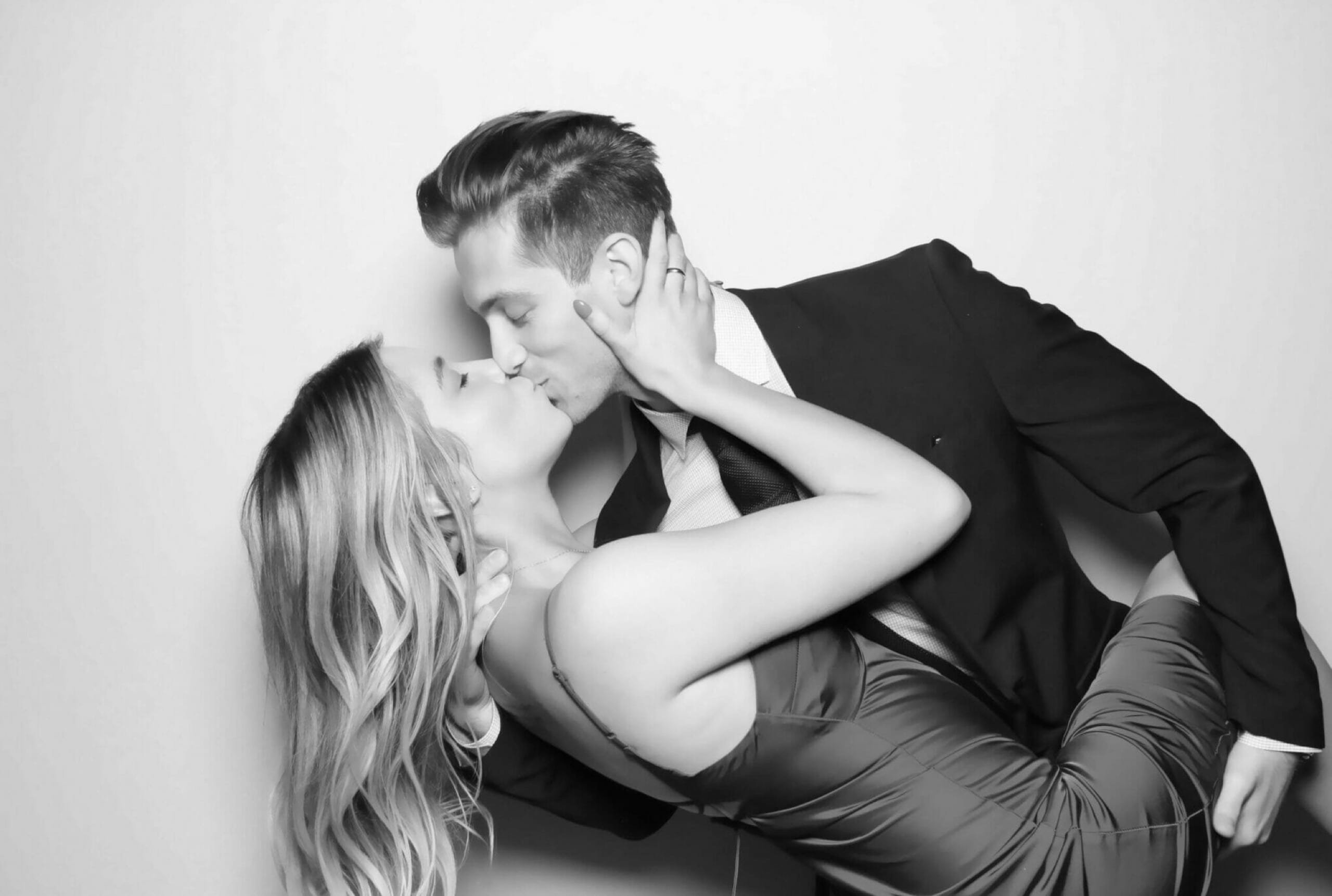 A couple caught mid dip and kiss in the glam booth