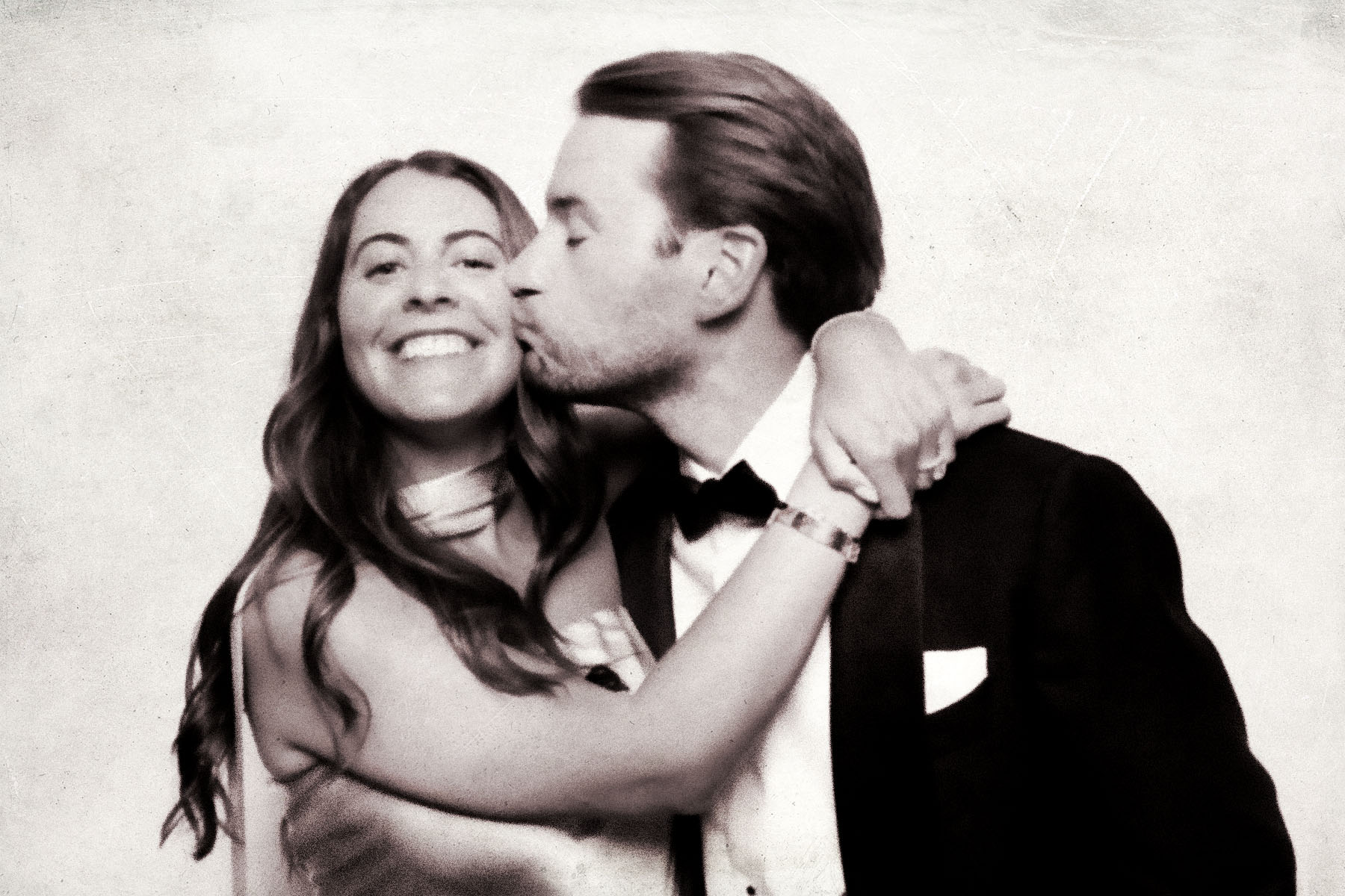 Vintage booth portrait of a couple with the warm tones and soft grain of a chemical photo booth